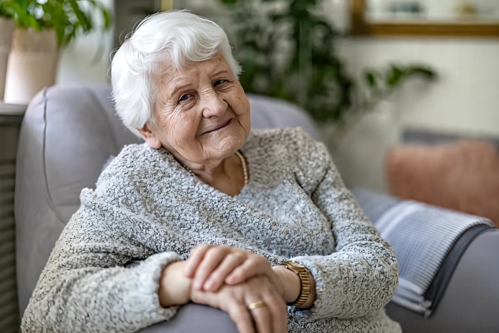 An older woman with a scarf seated by a window, mid-conversation